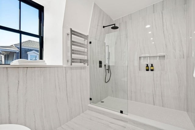 bathroom with a tile shower and radiator heating unit