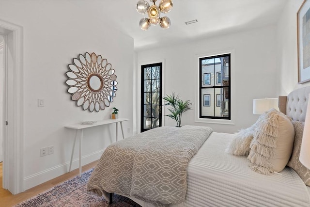 bedroom featuring wood-type flooring and a chandelier