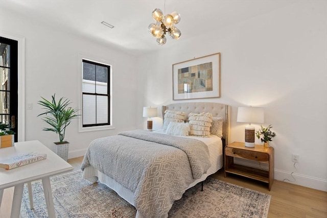 bedroom featuring hardwood / wood-style flooring and an inviting chandelier