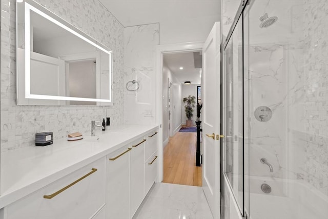 bathroom featuring enclosed tub / shower combo and vanity