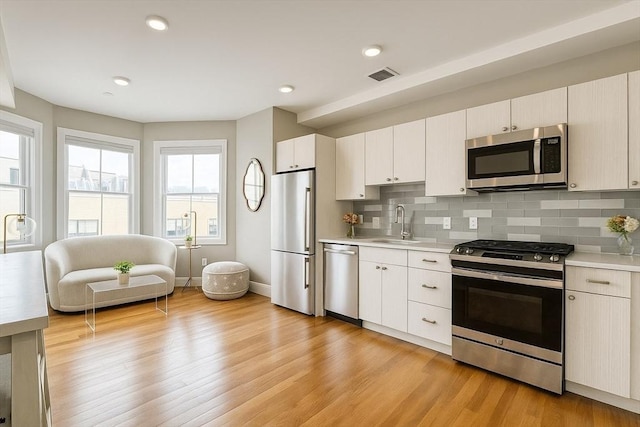 89 Prescott St Unit C, Boston, MA 02128 - kitchen with appliances with stainless steel finishes, light countertops, backsplash, and recessed lighting