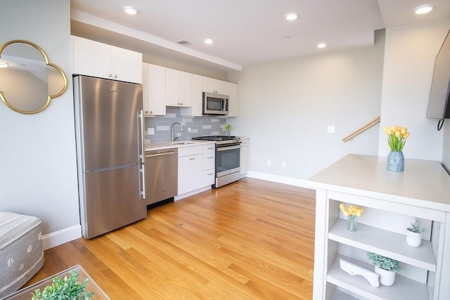 89 Prescott St Unit C, Boston, MA 02128 - kitchen featuring appliances with stainless steel finishes, white cabinetry, light countertops, light wood-type flooring, and recessed lighting