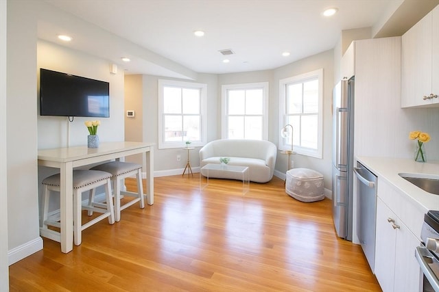 89 Prescott St Unit C, Boston, MA 02128 - kitchen featuring light wood finished floors, appliances with stainless steel finishes, light countertops, white cabinets, and recessed lighting