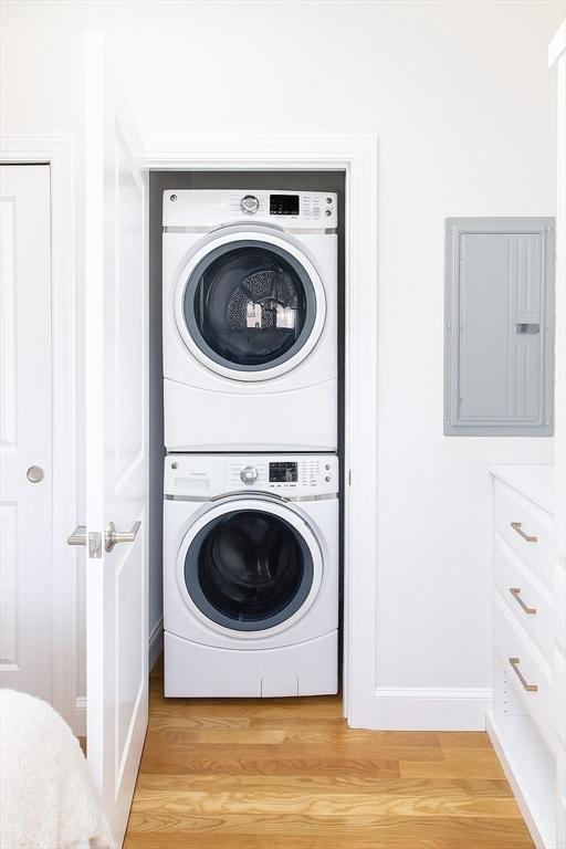 89 Prescott St Unit C, Boston, MA 02128 - laundry area featuring stacked washer / dryer, electric panel, and light wood-style floors