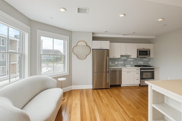 89 Prescott St Unit C, Boston, MA 02128 - kitchen with appliances with stainless steel finishes, healthy amount of natural light, light countertops, white cabinetry, and recessed lighting