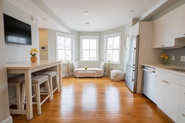 89 Prescott St Unit C, Boston, MA 02128 - kitchen featuring dishwasher, freestanding refrigerator, light wood-style floors, light countertops, and backsplash
