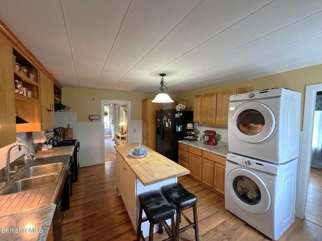 56-58 N Summer St, Adams, MA 01220 - laundry area with estacked washer and dryer, light wood-style floors, and a wainscoted wall
