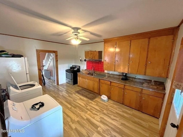 56-58 N Summer St, Adams, MA 01220 - kitchen with stainless steel gas stove, freestanding refrigerator, washer / clothes dryer, brown cabinetry, and a wainscoted wall