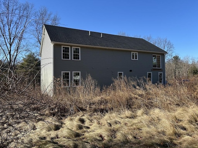 rear view of house with a shingled roof