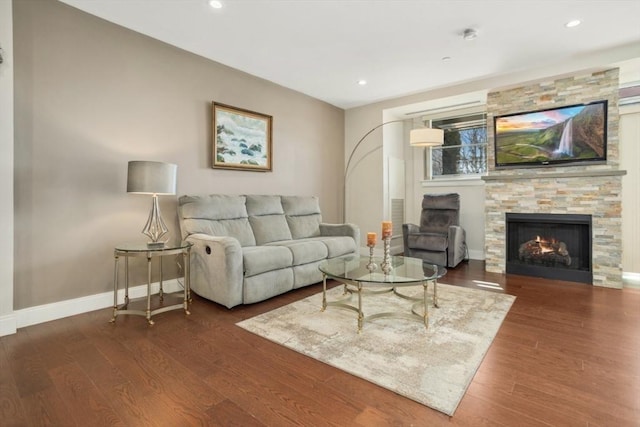 living room with a fireplace, recessed lighting, wood finished floors, and baseboards