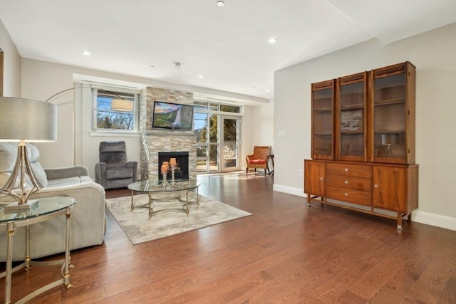 living area with recessed lighting, baseboards, dark wood-type flooring, and a fireplace