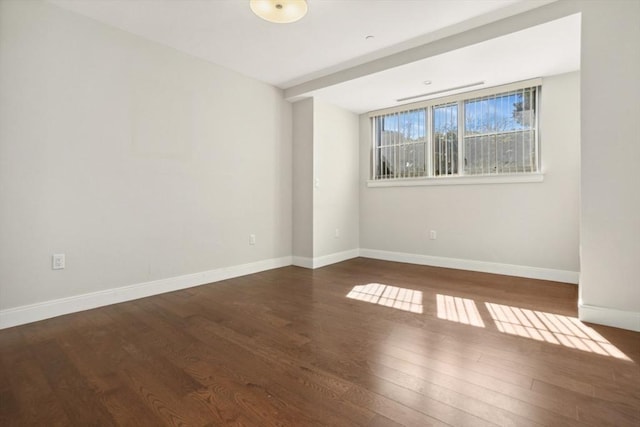 empty room featuring baseboards and wood finished floors