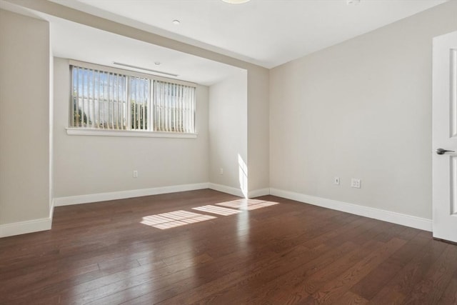 unfurnished room featuring baseboards and wood-type flooring