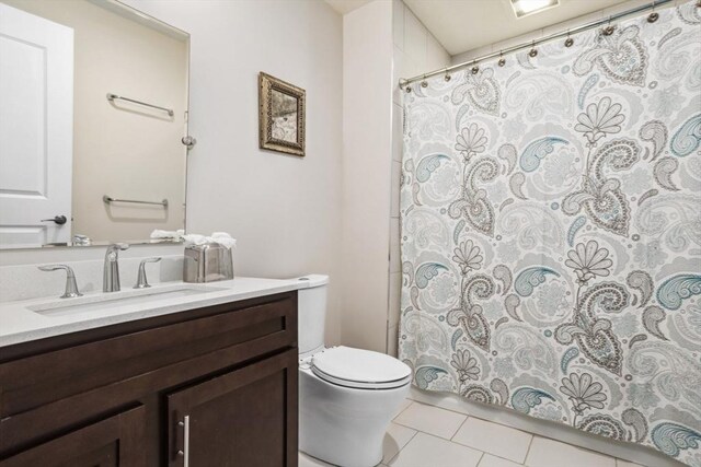 bathroom featuring tile patterned floors, a shower with shower curtain, toilet, and vanity