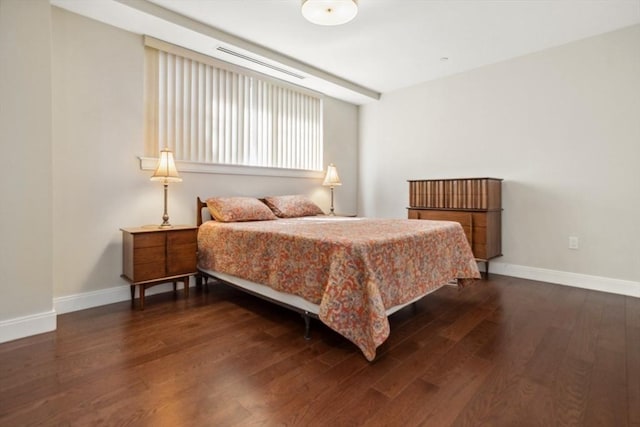 bedroom with dark wood finished floors and baseboards