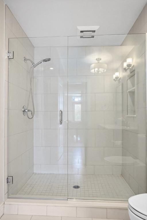 bathroom with visible vents, a stall shower, and toilet