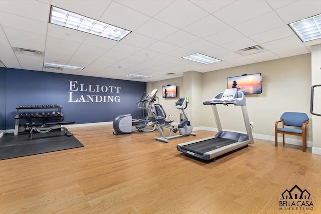 workout area with wood finished floors, visible vents, and a paneled ceiling