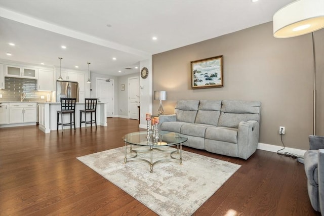 living area featuring recessed lighting, baseboards, and dark wood-style flooring