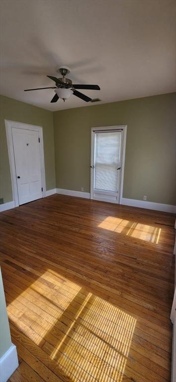 unfurnished room with hardwood / wood-style flooring and ceiling fan