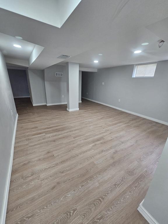 basement with light hardwood / wood-style flooring