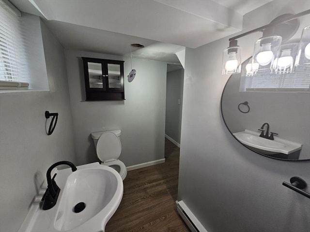 bathroom with toilet, sink, and hardwood / wood-style floors