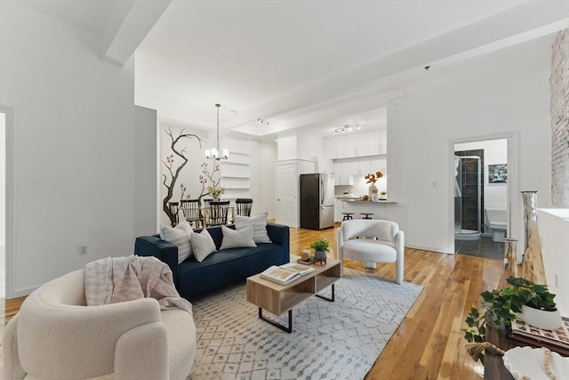 69 Harvey St Unit 1, Cambridge, MA 02140 - living room featuring a chandelier, light wood-style floors, and baseboards