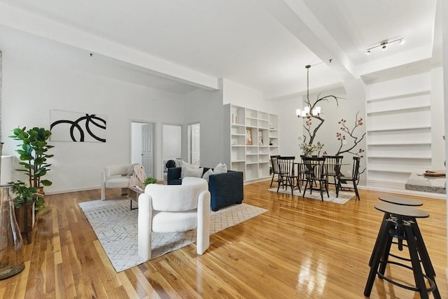 69 Harvey St Unit 1, Cambridge, MA 02140 - living area with a chandelier, light wood finished floors, beam ceiling, and baseboards