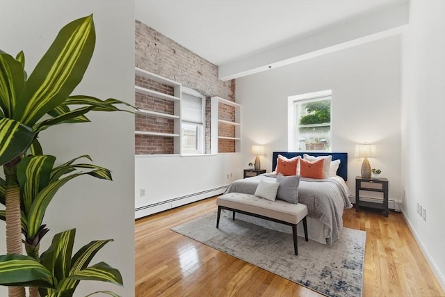 69 Harvey St Unit 1, Cambridge, MA 02140 - bedroom featuring a baseboard heating unit, wood finished floors, and brick wall