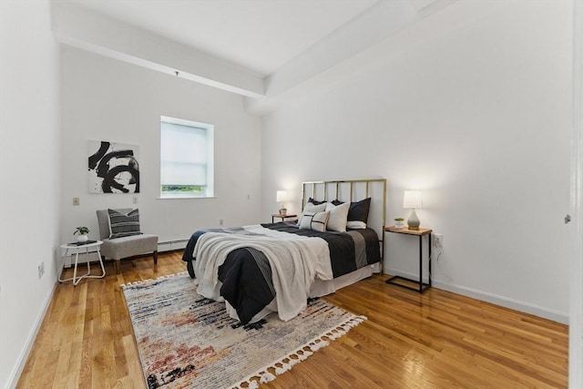 69 Harvey St Unit 1, Cambridge, MA 02140 - bedroom with wood finished floors, baseboards, baseboard heating, and a baseboard heating unit