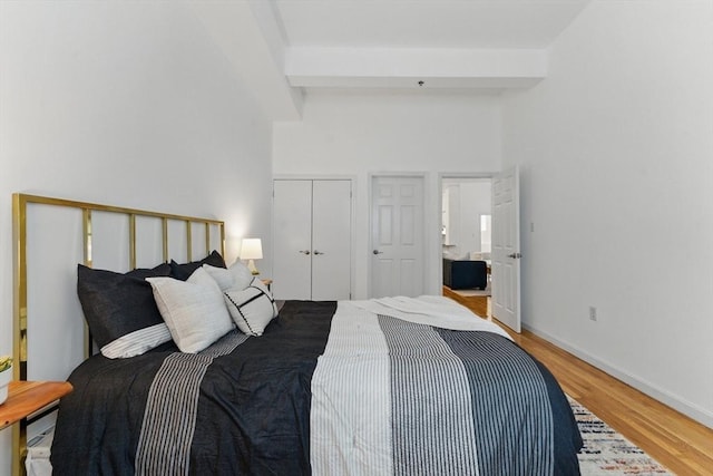 69 Harvey St Unit 1, Cambridge, MA 02140 - bedroom featuring light wood-style floors, beamed ceiling, a closet, and baseboards