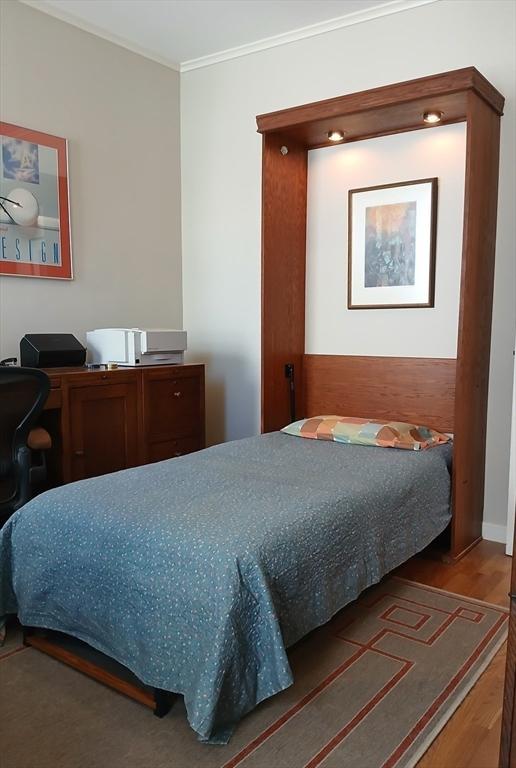 bedroom featuring crown molding and wood finished floors