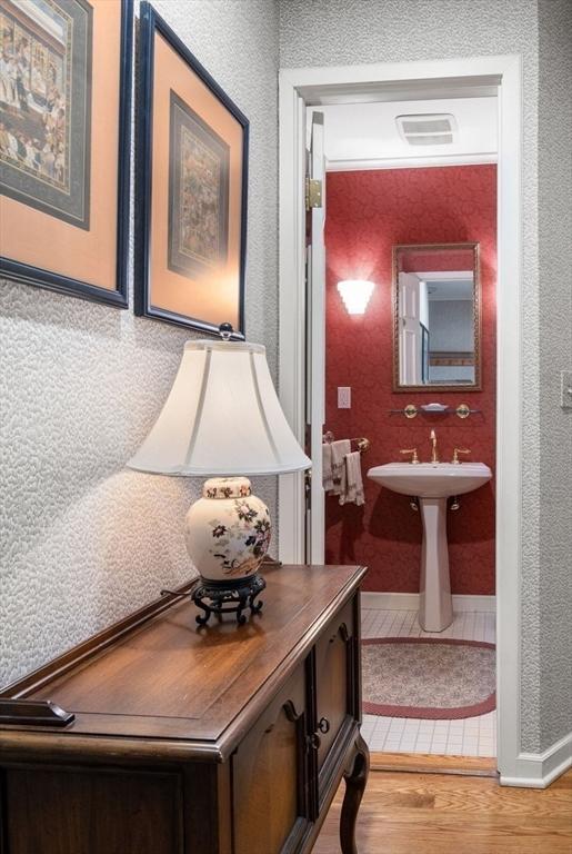 bathroom with baseboards, wood finished floors, and visible vents