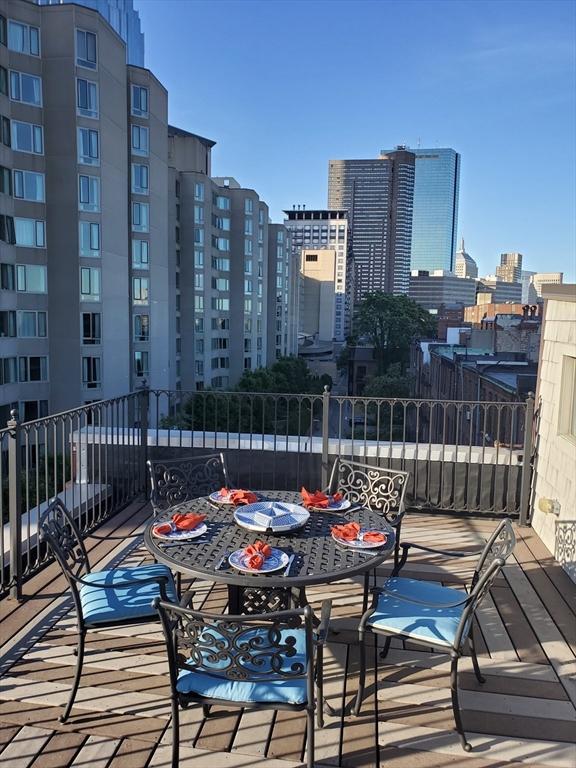 wooden deck featuring a view of city and outdoor dining area