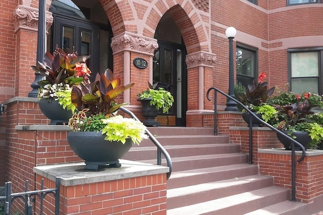 doorway to property with brick siding and covered porch