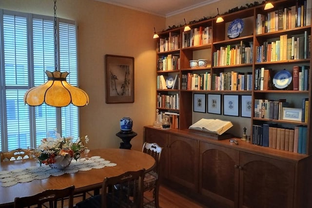 dining space with crown molding and wood finished floors