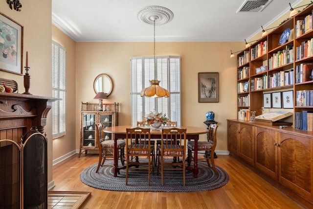 dining area featuring baseboards, visible vents, and light wood-style floors