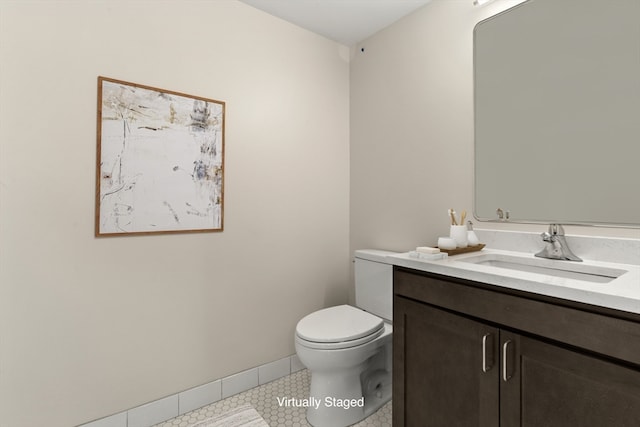 bathroom with tile patterned flooring, vanity, and toilet