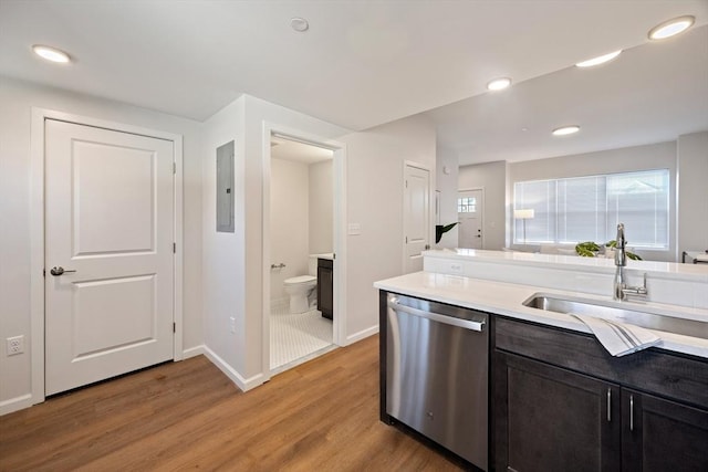 kitchen featuring electric panel, dishwasher, light hardwood / wood-style flooring, and sink