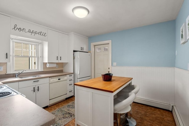 kitchen featuring sink, baseboard heating, a kitchen island, white appliances, and white cabinets