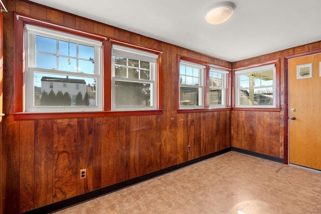 unfurnished room with wood walls