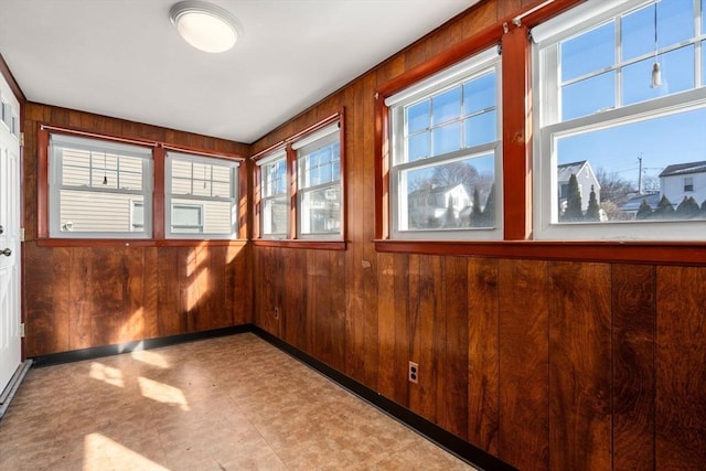 unfurnished room with wood walls