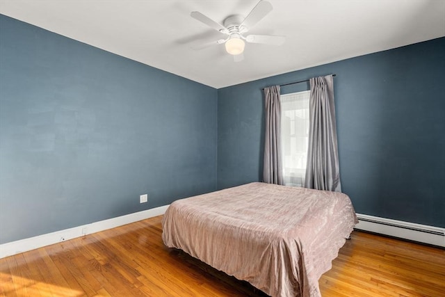 bedroom featuring hardwood / wood-style flooring, ceiling fan, and baseboard heating