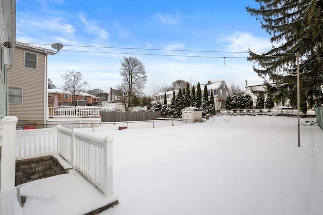 snowy yard featuring a storage unit