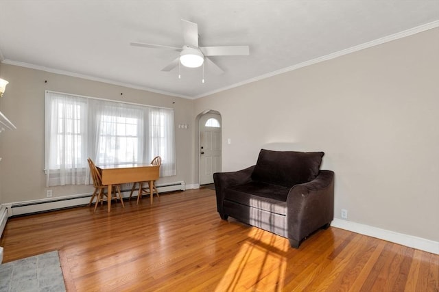 living room featuring hardwood / wood-style flooring, crown molding, and a baseboard heating unit