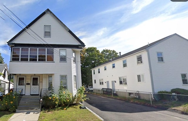 view of front of property featuring fence and covered porch