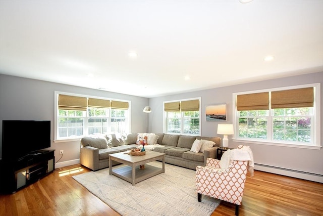 living area with recessed lighting, baseboards, a baseboard heating unit, and wood finished floors
