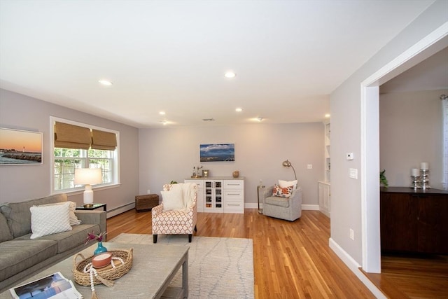 living area featuring recessed lighting, baseboards, a baseboard heating unit, and light wood finished floors