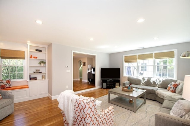 living room with recessed lighting, baseboards, and light wood-style floors