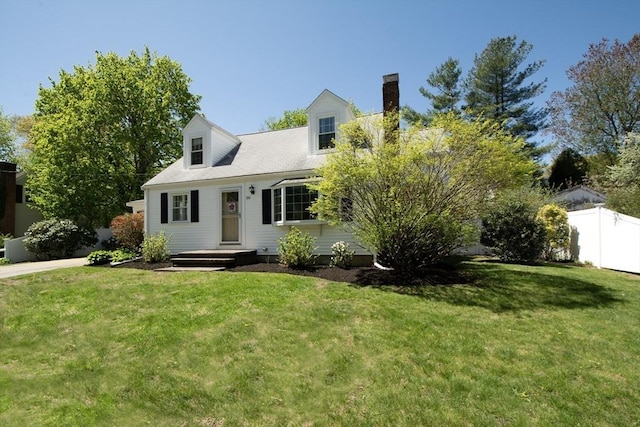 cape cod home featuring a front lawn, fence, and a chimney