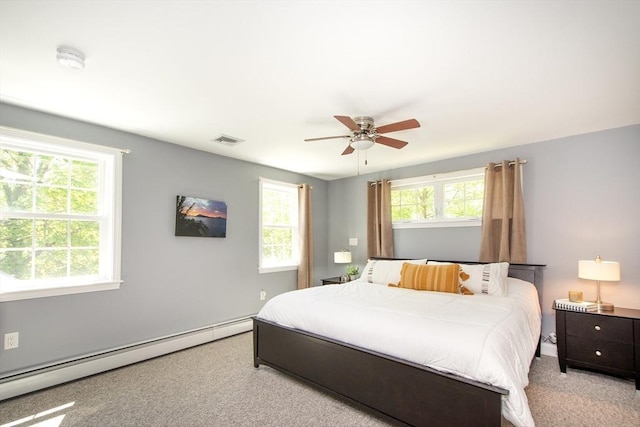 bedroom with carpet floors, ceiling fan, a baseboard heating unit, and visible vents